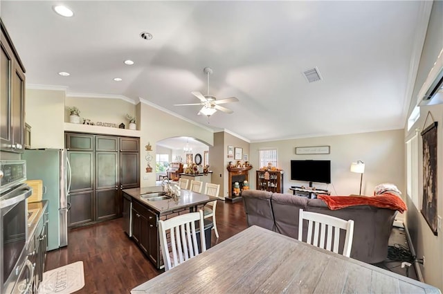 kitchen with appliances with stainless steel finishes, crown molding, sink, dark hardwood / wood-style floors, and lofted ceiling