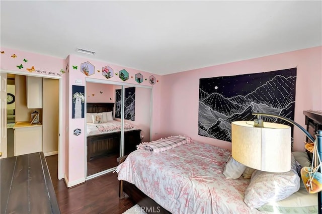 bedroom featuring dark hardwood / wood-style flooring and a closet