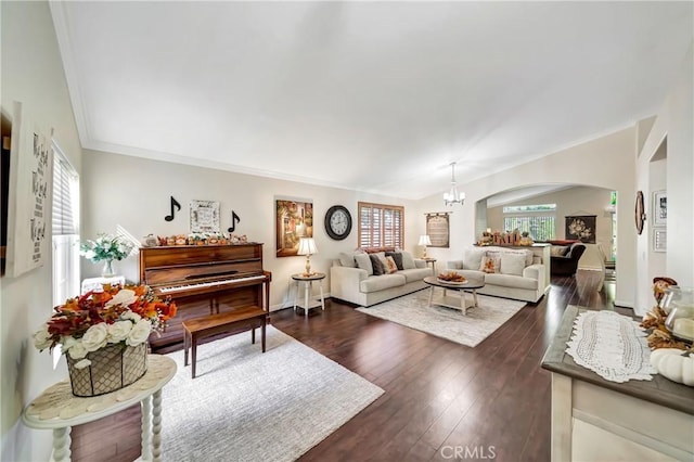 living room featuring dark hardwood / wood-style floors, an inviting chandelier, and crown molding