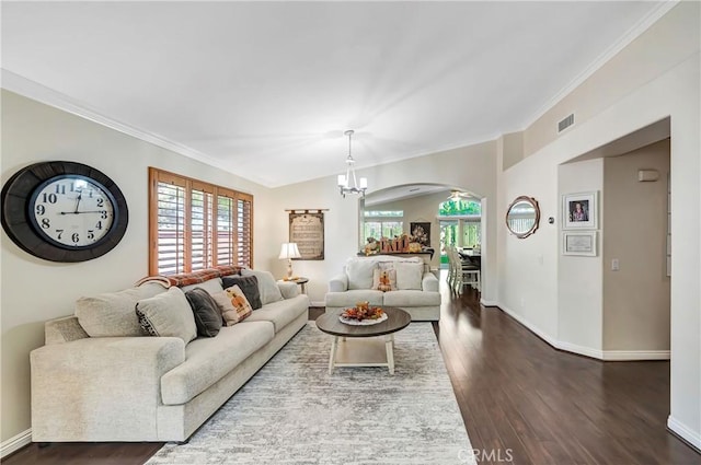 living room featuring a chandelier, hardwood / wood-style floors, and crown molding