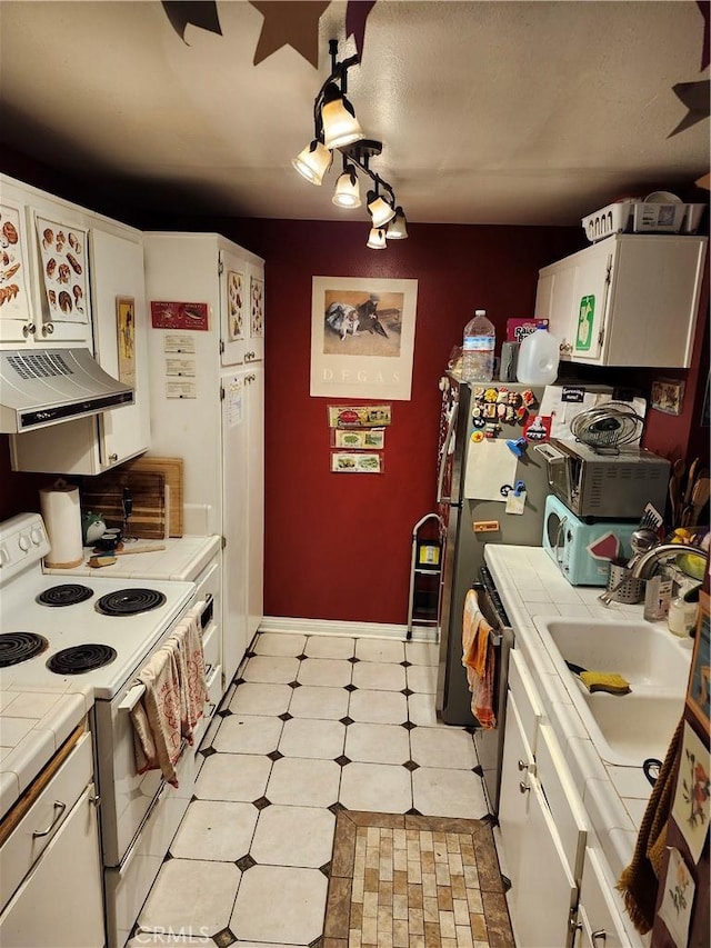 kitchen with ventilation hood, tile counters, white cabinetry, and electric stove