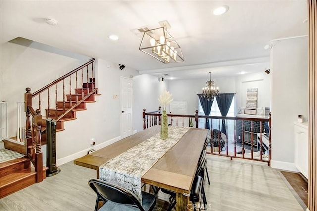 dining area featuring light hardwood / wood-style floors and an inviting chandelier