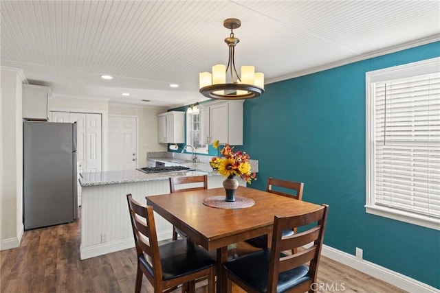 553 E 23rd St, Chico, CA 95928 - dining space with a chandelier, healthy amount of natural light, dark wood-style flooring, recessed lighting, and ornamental molding
