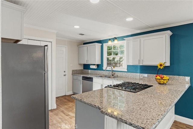 kitchen featuring white cabinetry, sink, stainless steel appliances, light hardwood / wood-style flooring, and kitchen peninsula