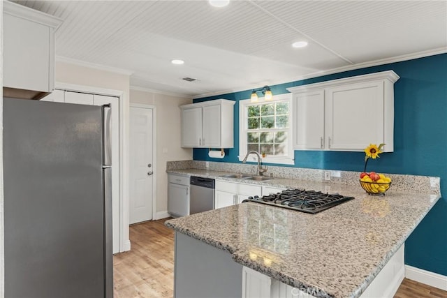 553 E 23rd St, Chico, CA 95928 - kitchen with stainless steel appliances, ornamental molding, a peninsula, light wood-style flooring, and white cabinetry