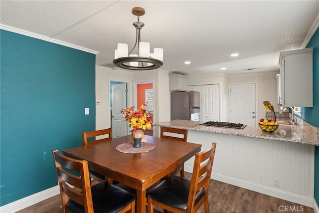 dining room with dark hardwood / wood-style floors, crown molding, and sink