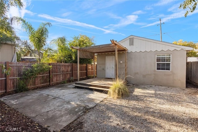 rear view of property featuring a patio area and a wooden deck