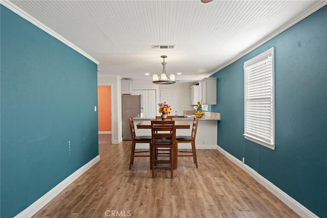 553 E 23rd St, Chico, CA 95928 - dining area with ornamental molding, a chandelier, and wood finished floors