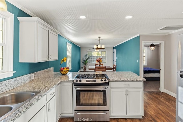 kitchen featuring kitchen peninsula, dark hardwood / wood-style floors, white cabinetry, and stainless steel range with gas stovetop