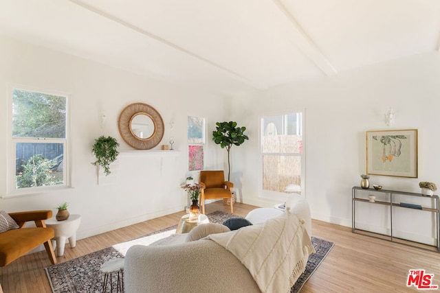 living room with beam ceiling and light wood-type flooring