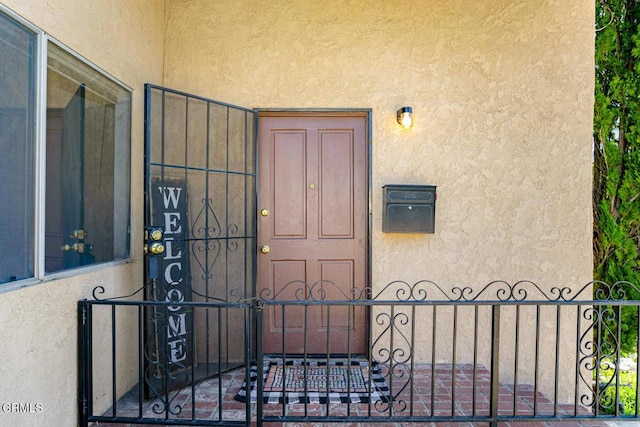 property entrance with a gate and stucco siding