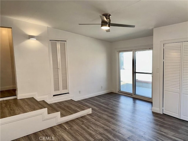 unfurnished living room featuring ceiling fan and dark hardwood / wood-style flooring