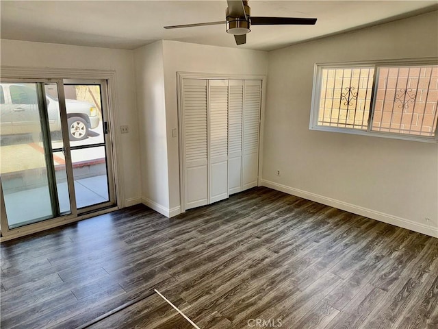 unfurnished bedroom with dark hardwood / wood-style flooring, ceiling fan, a closet, and access to exterior