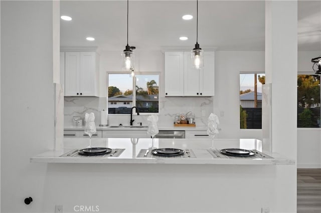 kitchen with white cabinets, pendant lighting, a wealth of natural light, and sink