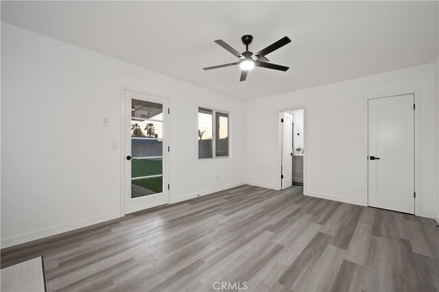 unfurnished bedroom with ceiling fan, ensuite bathroom, and light hardwood / wood-style flooring