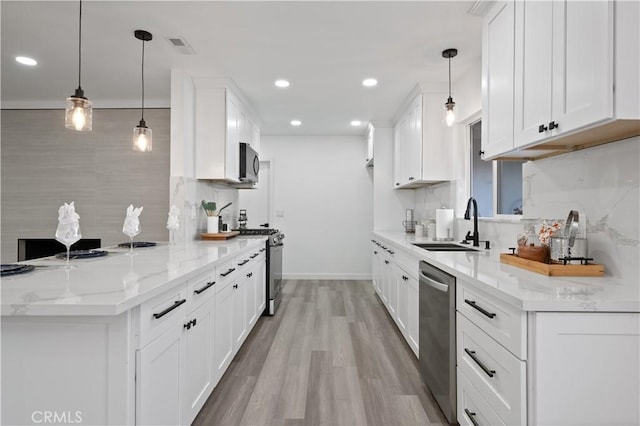 kitchen with white cabinets, stainless steel appliances, and hanging light fixtures