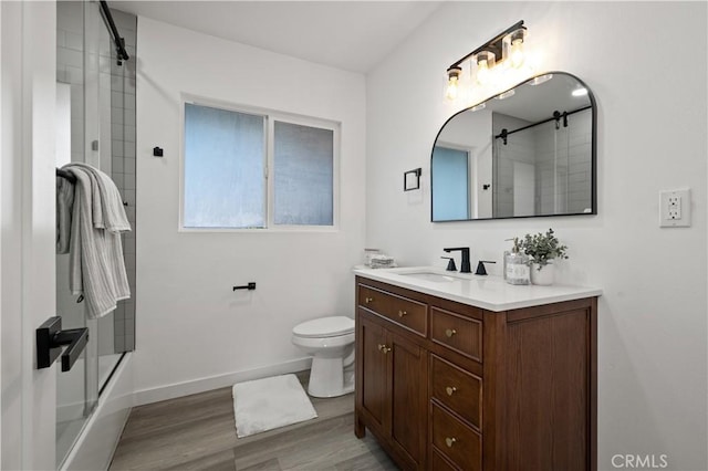 full bathroom featuring enclosed tub / shower combo, vanity, wood-type flooring, and toilet