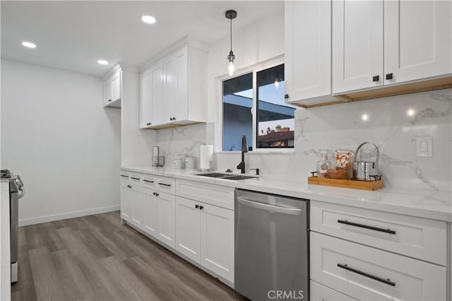 kitchen featuring stainless steel appliances, tasteful backsplash, pendant lighting, wood-type flooring, and white cabinets