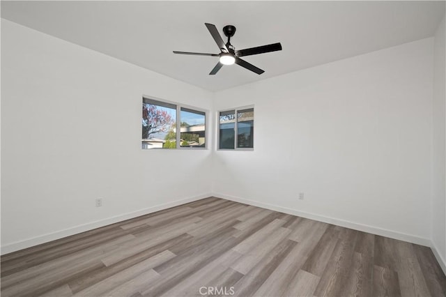 spare room with light wood-type flooring and ceiling fan