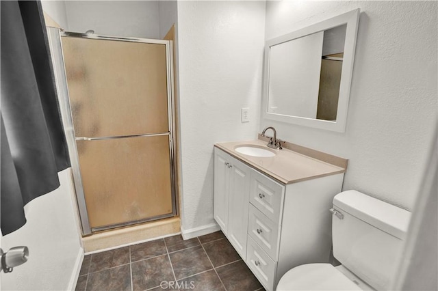 bathroom featuring tile patterned flooring, vanity, toilet, and a shower with door