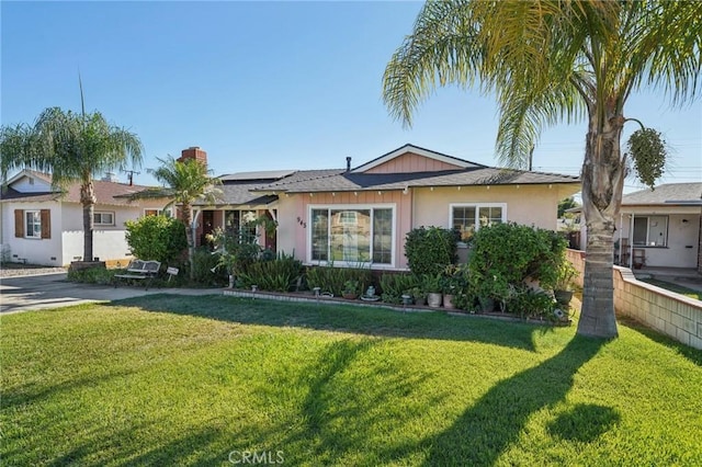 view of front of property with solar panels and a front lawn