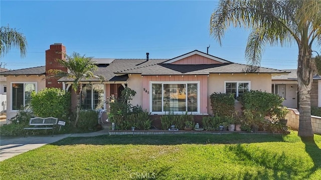 view of front of property featuring solar panels and a front yard