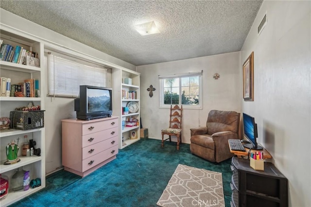 sitting room featuring a textured ceiling and dark colored carpet