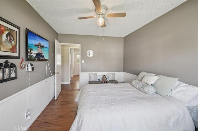 bedroom featuring ceiling fan, wood-type flooring, and a textured ceiling