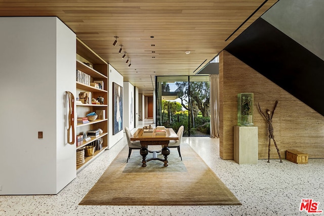 dining space with a wall of windows, wood ceiling, and rail lighting