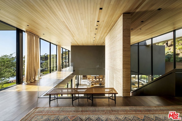 interior space with floor to ceiling windows, a wealth of natural light, hardwood / wood-style floors, and wood ceiling