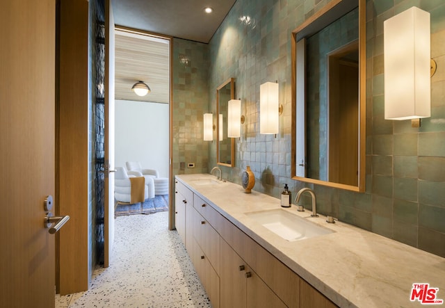 bathroom with vanity and tile walls