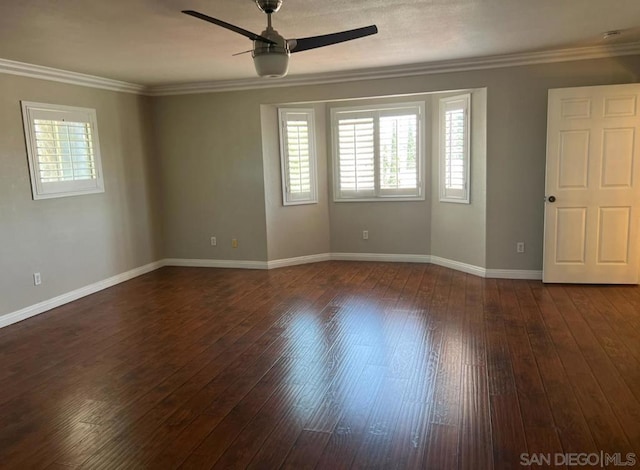 empty room with ceiling fan, a healthy amount of sunlight, and dark hardwood / wood-style flooring