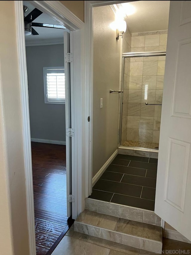 bathroom with hardwood / wood-style flooring, ornamental molding, and a shower with door