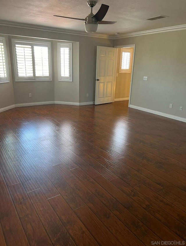 unfurnished room with ceiling fan, dark wood-type flooring, a textured ceiling, and ornamental molding