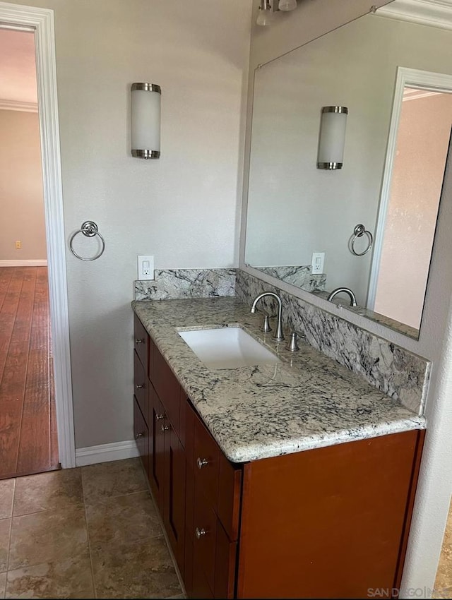 bathroom featuring hardwood / wood-style floors, vanity, and ornamental molding