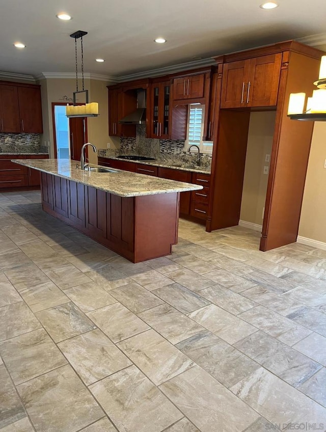 kitchen featuring pendant lighting, wall chimney exhaust hood, light stone countertops, and backsplash