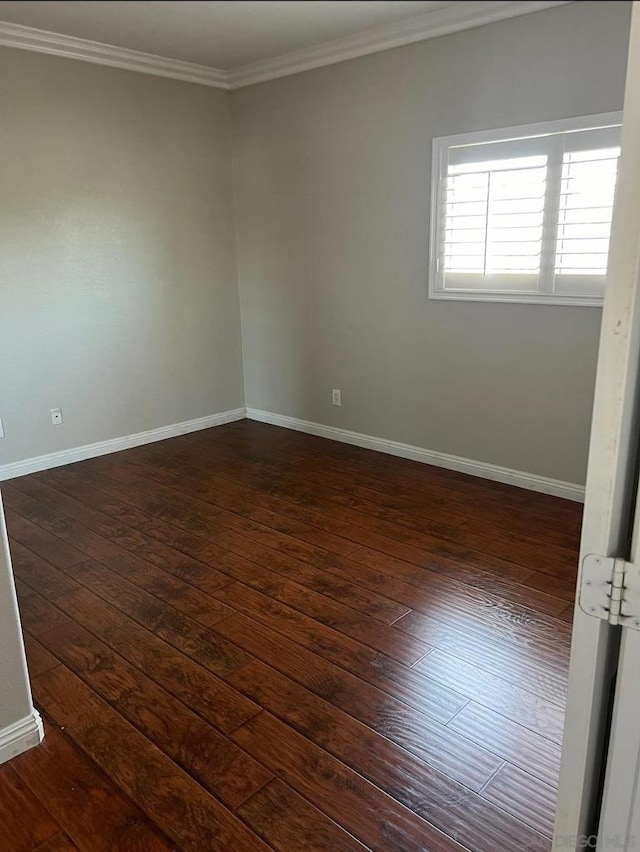 empty room featuring dark hardwood / wood-style flooring and crown molding