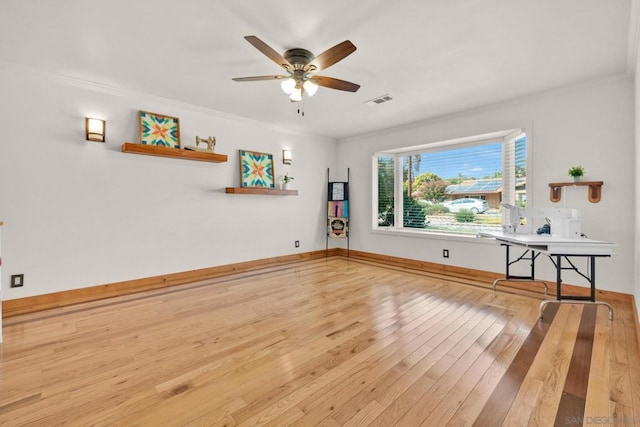 unfurnished living room with ceiling fan, ornamental molding, and wood-type flooring