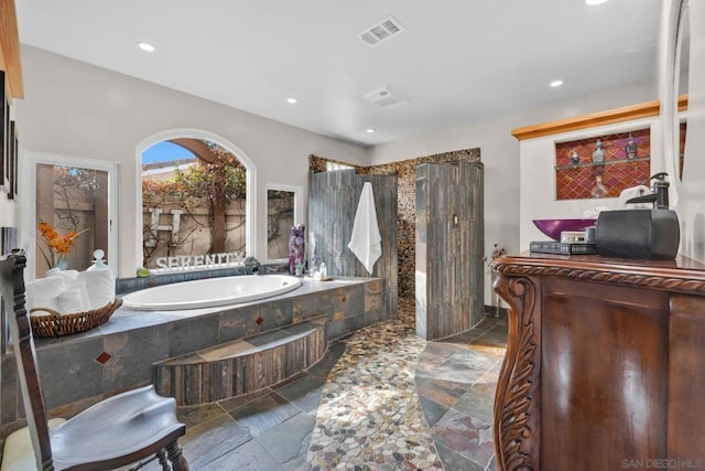 bathroom with a relaxing tiled tub