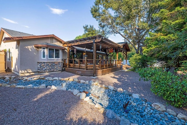 rear view of property with a pergola and a wooden deck