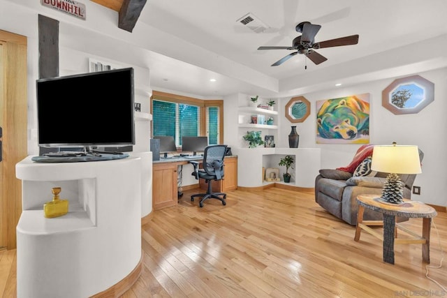 office space featuring light hardwood / wood-style floors, built in desk, and ceiling fan