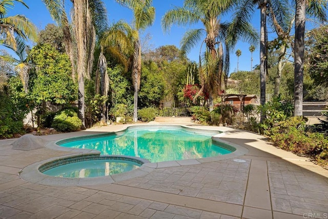 view of pool with an in ground hot tub and a patio