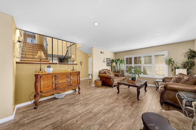 living room featuring recessed lighting, wood finished floors, visible vents, baseboards, and stairs