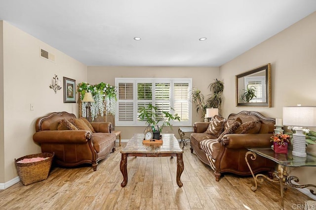 living area featuring light wood-style floors, baseboards, visible vents, and recessed lighting