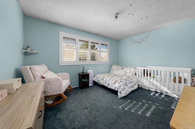 bedroom with a textured ceiling and dark carpet