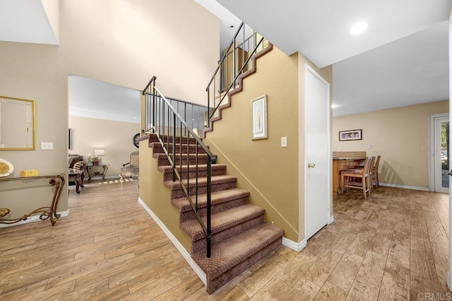 stairs featuring recessed lighting, wood finished floors, and baseboards