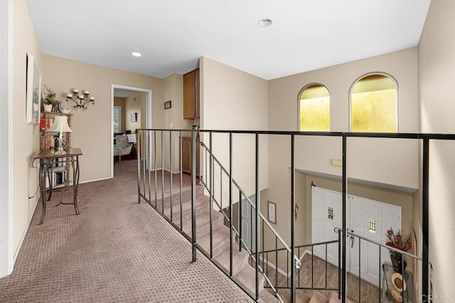 hallway with recessed lighting, baseboards, light colored carpet, and an upstairs landing