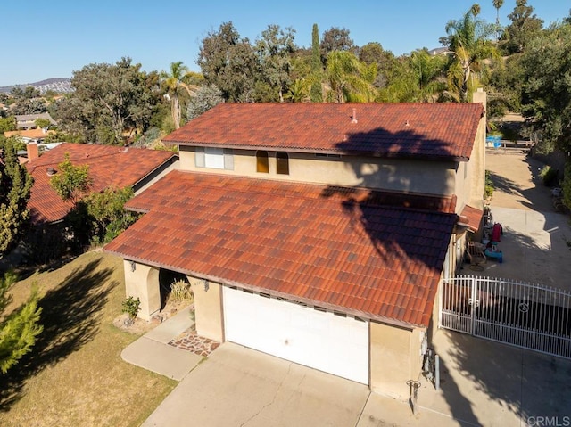 view of front of home featuring a garage, fence, a tiled roof, and stucco siding