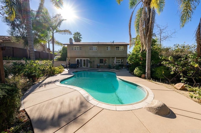 pool with a patio area and fence