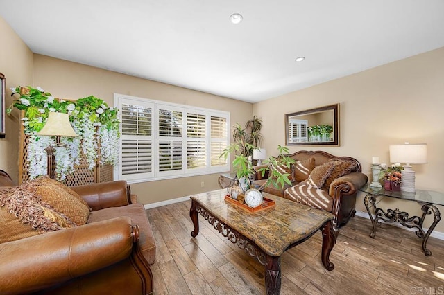 living room with light wood-type flooring, baseboards, and recessed lighting